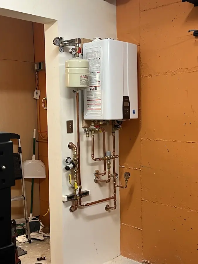 Plumbing technician inspecting water heater connections in Perrysburg
